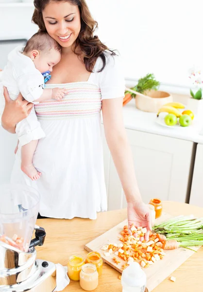 Mama radiantă pregătește mâncare pentru copilul ei adorabil în tricou — Fotografie, imagine de stoc