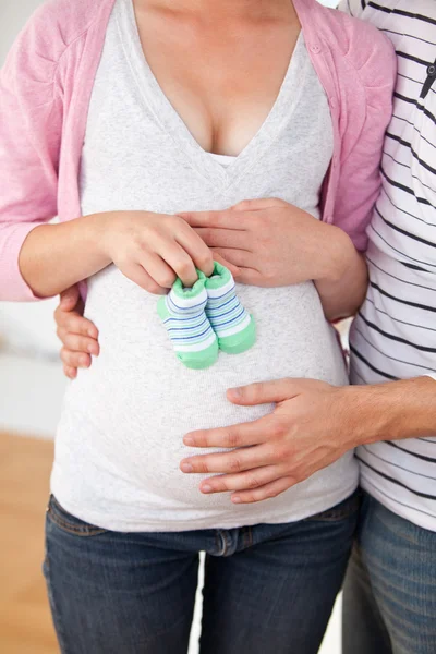 클로즈업 아기 신발 들고 백인 임신 여자의 고의 — 스톡 사진