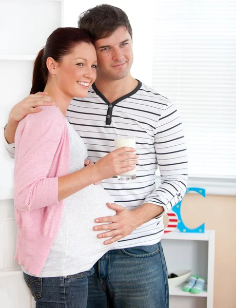 Porträtt av en leende gravid kvinna med ett glas mjölk och — Stockfoto