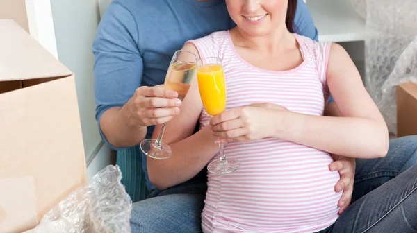 Sorrindo casal esperando um bebê bebendo e sentado no floo — Fotografia de Stock