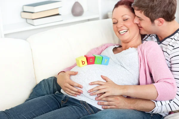 Portrét veselé těhotné ženy s baby kostky na břiše — Stock fotografie