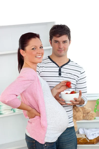 Portret uśmiechający się kobieta w ciąży, jedzenie truskawek i z — Zdjęcie stockowe