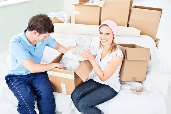Concentrado jovem casal desempacotar caixas com óculos — Fotografia de Stock