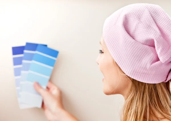 Jovem atraente escolhendo cor para pintar uma sala — Fotografia de Stock