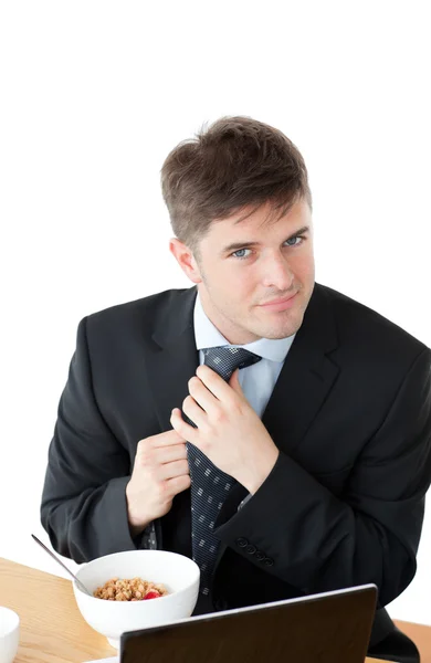 Elegant businessman having breakfast and touching his tie in fro — Stock Photo, Image