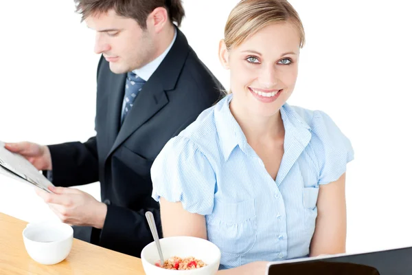Paar van Glimlachende zakenmensen met behulp van laptop en lezing newspa — Stockfoto