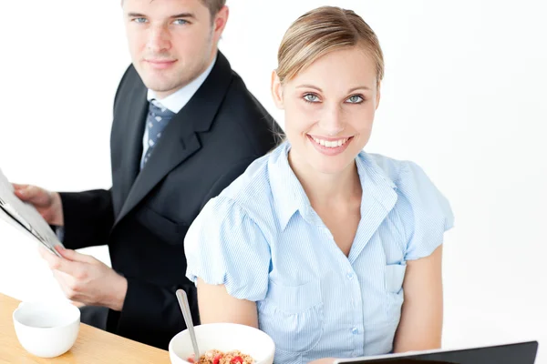 Пара улыбающихся бизнесменов, пользующихся ноутбуком и читающих новости — стоковое фото