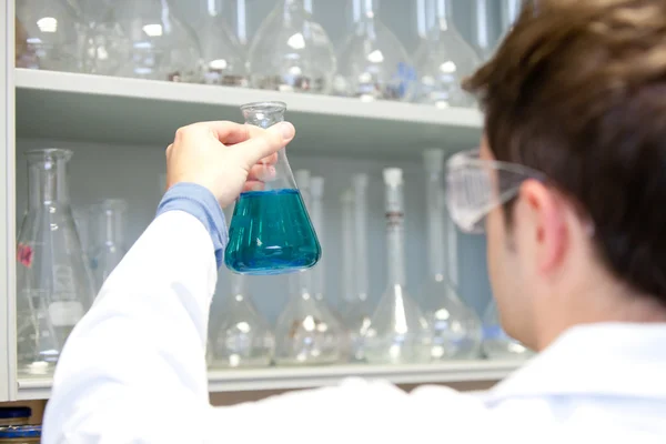 Young scientist looking at an erlenmeyer — Stock Photo, Image
