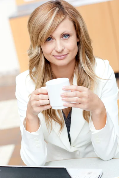 Mujer de negocios brillante sosteniendo una taza de café en frente de su regazo —  Fotos de Stock