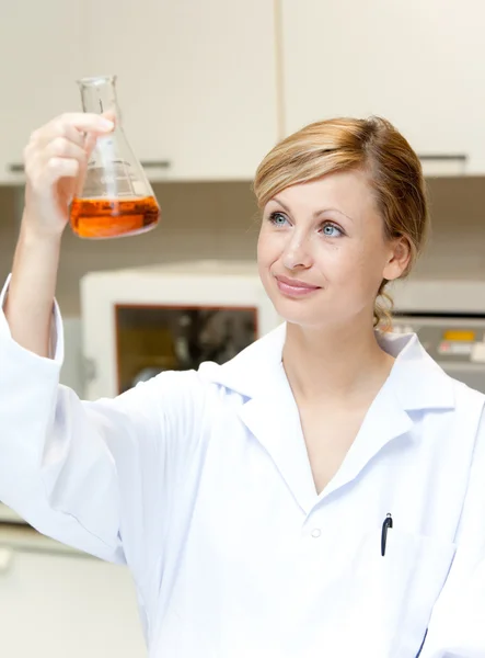 Porträt einer aufgeweckten Wissenschaftlerin beim Anblick eines Erlenmeyers — Stockfoto