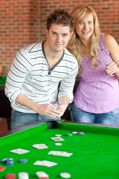 Casal caucasiano jogando cartas em um bilhar — Fotografia de Stock