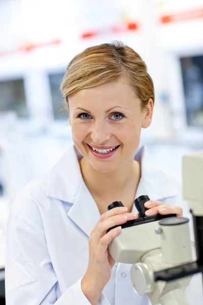 Задоволена жінка-вчена використовує мікроскоп — стокове фото