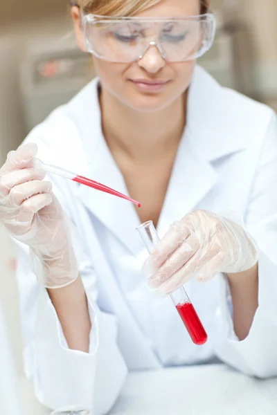 Närbild av en koncentrerad kvinnliga forskare att vätskan i en — Stockfoto