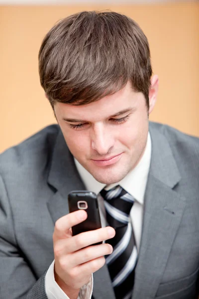 Empresário autoconfiante escrevendo uma mensagem de texto com seu celular — Fotografia de Stock