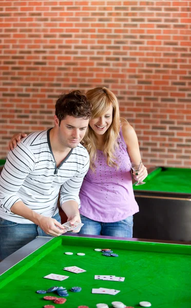 Cheerful couple playing cards on a billiard — Stock Photo, Image