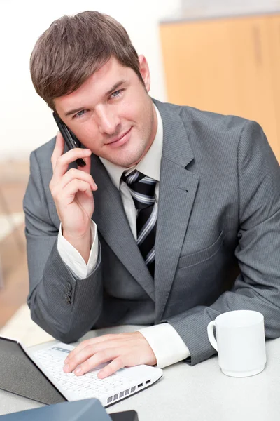 Vertrouwen zakenman praten over telefoon en met behulp van zijn laptop — Stockfoto