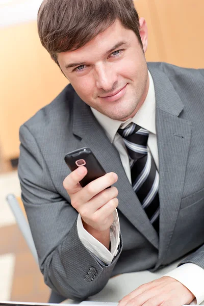 Empresário elegante escrevendo uma mensagem de texto com seu telefone celular — Fotografia de Stock