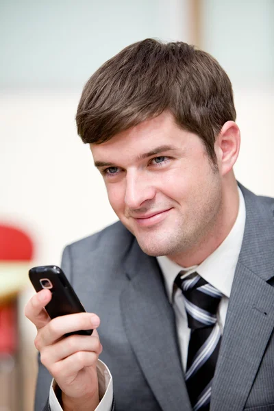 Portrait of an assertive businessman sending a text message with — Stock Photo, Image