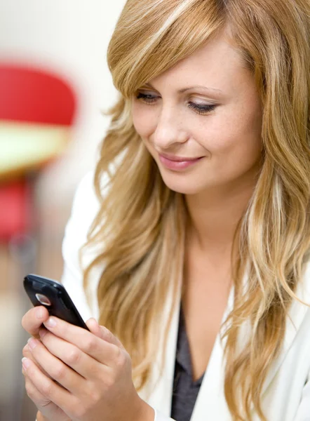 Strahlende Geschäftsfrau schickt SMS mit dem Handy — Stockfoto