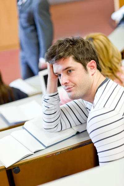 Uttråkad manlig student under en universitet lektion — Stockfoto