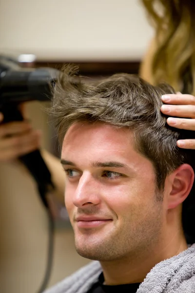 Peluquería femenina secando el cabello de su cliente masculino — Foto de Stock