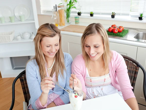 Two cute friends eating an ice-cream together sitting in the kit — Stock Photo, Image