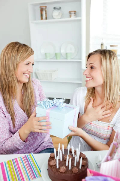 Pleased woman receiving a gift during her birthday party at home — Stock Photo, Image