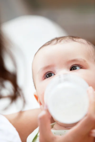 Primer plano de un bebé-biberón alimentado por su madre en casa — Foto de Stock