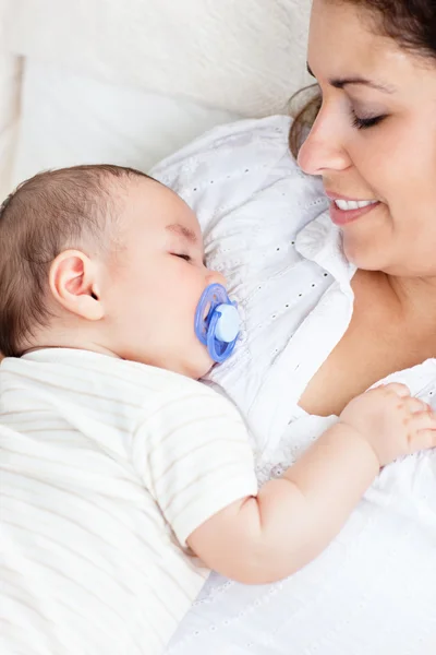 Portret van een schattige baby rustig slapen in de armen van zijn moeder — Stockfoto
