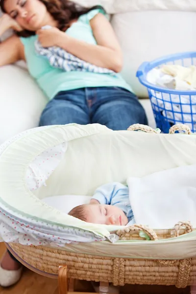Cute baby sleeping in his cradle with his mother lying on the co — Stock Photo, Image