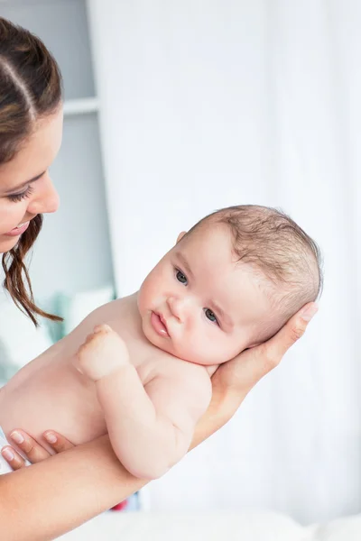 Banyo sonra bebeği tutarak dikkatli anne portresi — Stok fotoğraf
