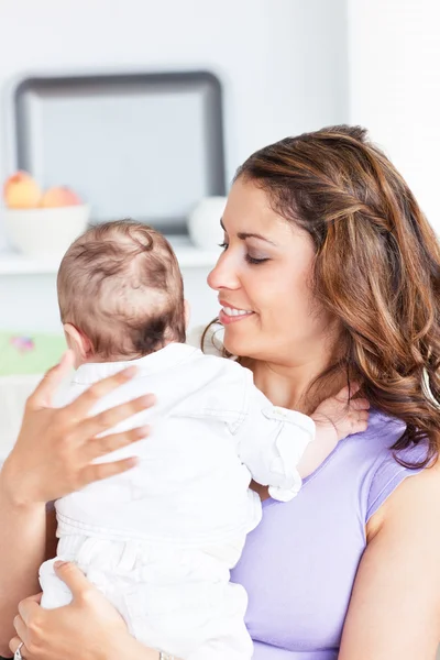 Portrait of a happy mother holding her newborn child standing in — Stock Photo, Image
