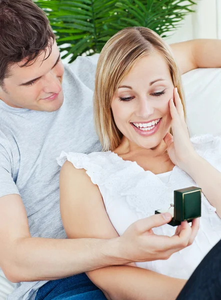 Счастливая женщина получает обручальное кольцо во время предложения дома — стоковое фото