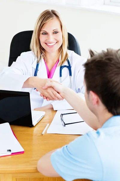 Дружеская женщина-врач пожимает руку пациентке, сидящей в ней — стоковое фото