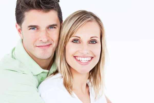 Adorable couple smiling at the camera and standing against a whi — Stock Photo, Image