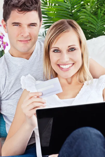 Glad couple buying online with credit card and laptop laying on — Stock Photo, Image