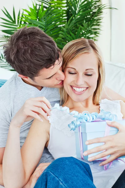 Uprzejmy człowiek całując jej dziewczyna po dając jej prezent — Zdjęcie stockowe