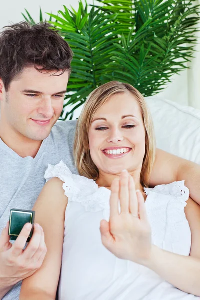 Blij vrouw kijken naar haar trouwring liggen met haar vriendje — Stockfoto