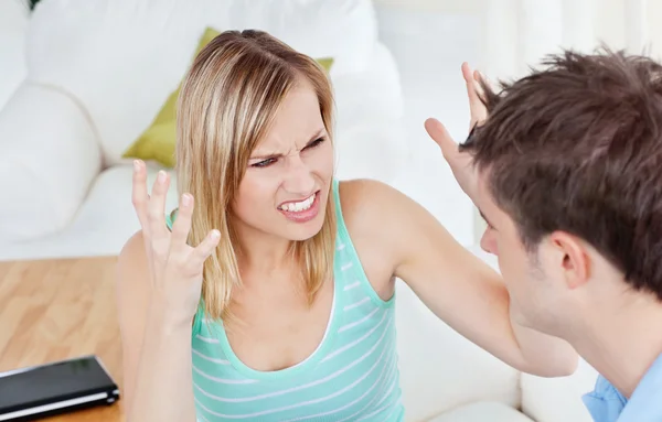 Angry woman getting worked up against her boyfriend both sitting — Stock Photo, Image