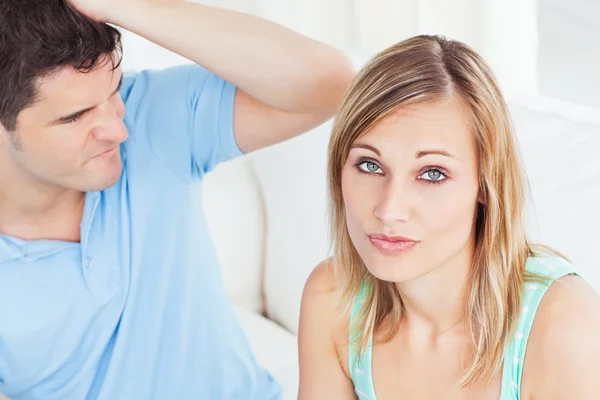Giovane donna ignorando il suo ragazzo seduto sul divano a casa — Foto Stock
