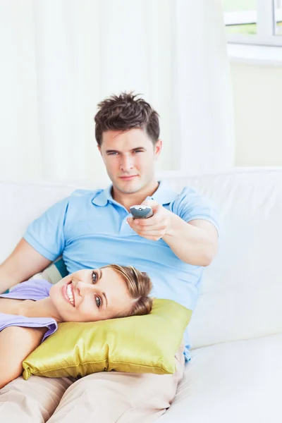 看一场电影在家里的沙发上放松对年轻夫妇 — 图库照片