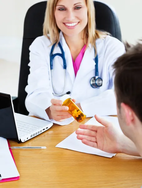 Портрет привлекательного врача, дающего таблетки пациентке Дур — стоковое фото