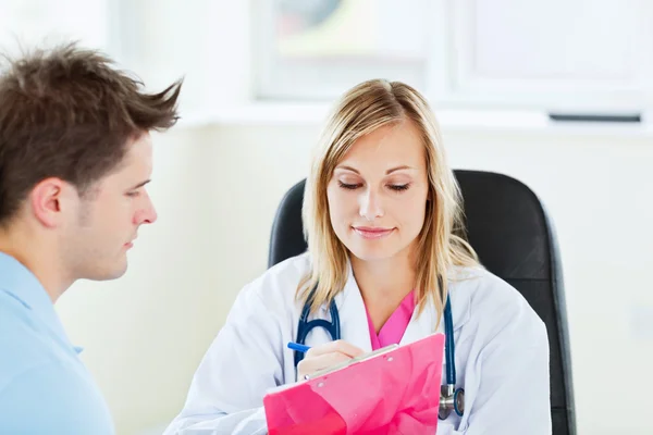 Concentrato medico femminile scrivendo una prescrizione per il suo paziente — Foto Stock