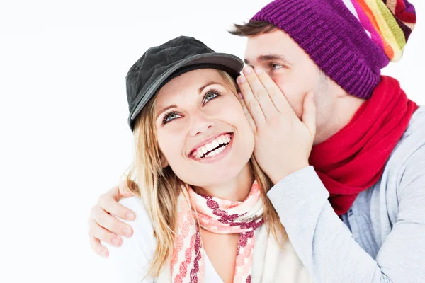 Bonito homem com chapéu contando um segredo para sua namorada rindo — Fotografia de Stock