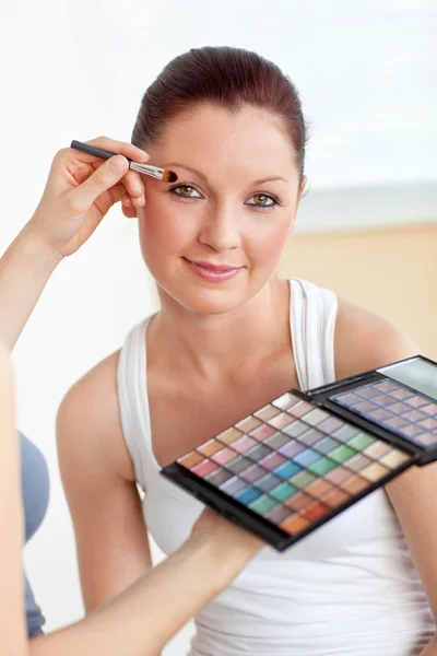 Make-up artist mettendo un po 'di ombretto su una bella donna — Foto Stock