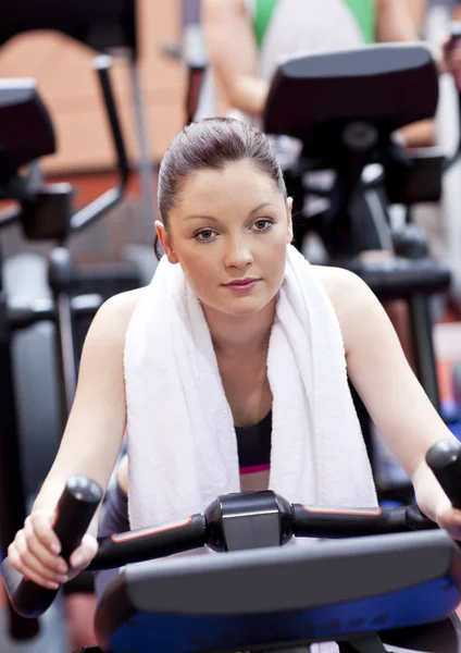 Grave donna atletica che pedala durante un allenamento in un centro sportivo — Foto Stock