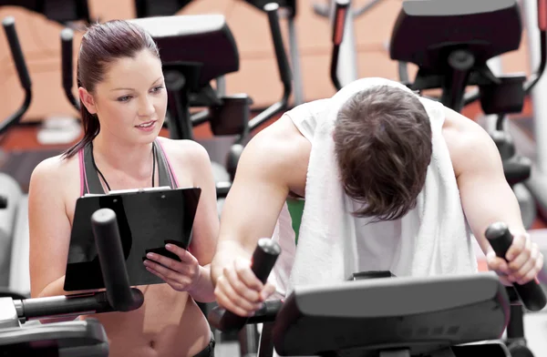 Exhausted man doing exercises while his coach is looking at his — Stock Photo, Image