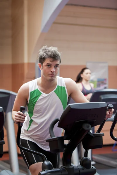 Bel homme faire des exercices à l'aide de cross-trainer dans une salle de fitness ce — Photo
