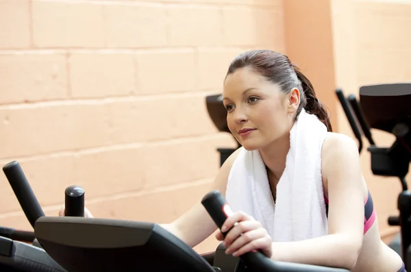 Beautiful woman training on a bicycle in a fitness center — Stock Photo, Image