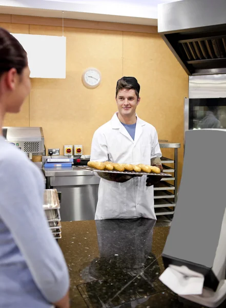 Mooie klant wachten op brood in een cafetaria en glimlachen — Stockfoto